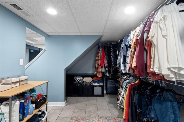 walk in closet with a paneled ceiling, tile patterned flooring, and visible vents