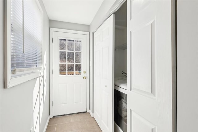 doorway to outside with light tile patterned floors