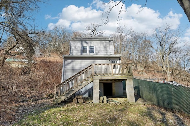 back of property with a deck and stairs