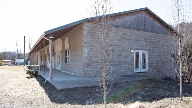 view of side of home featuring a patio and french doors