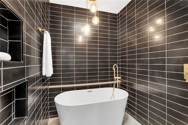 bathroom with a freestanding tub and tile walls