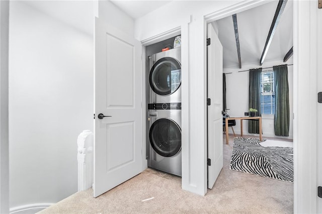 laundry area with laundry area, carpet flooring, and stacked washing maching and dryer