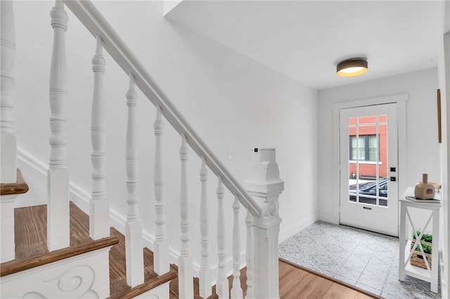 foyer featuring stairway, baseboards, and wood finished floors