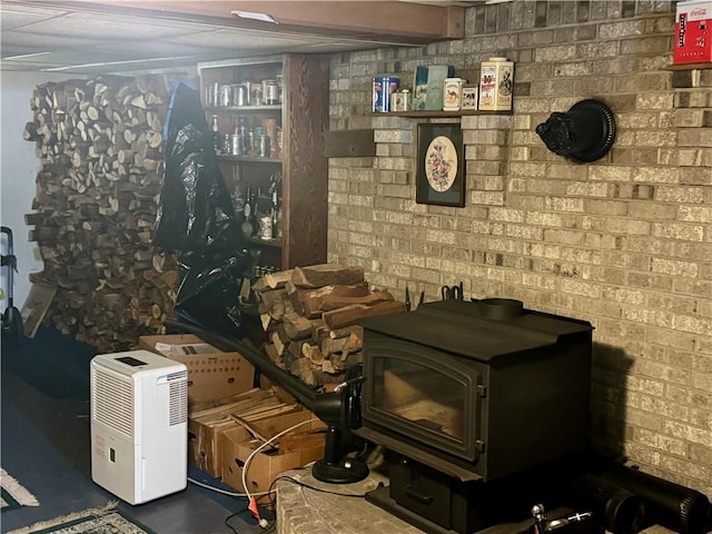 interior space with a wood stove and brick wall