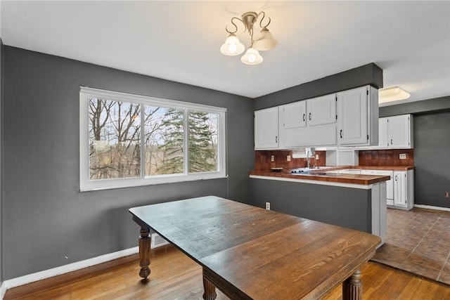 dining room featuring a chandelier, dark wood-style flooring, and baseboards