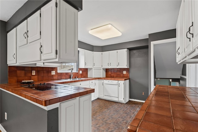 kitchen featuring white cabinetry, tile counters, black electric cooktop, and dishwasher