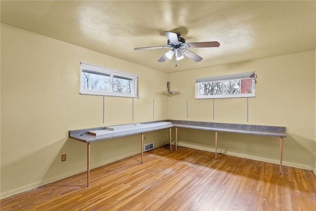 office space with hardwood / wood-style flooring, plenty of natural light, visible vents, and baseboards