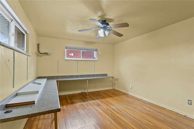 unfurnished office with wood-type flooring, baseboards, and a ceiling fan