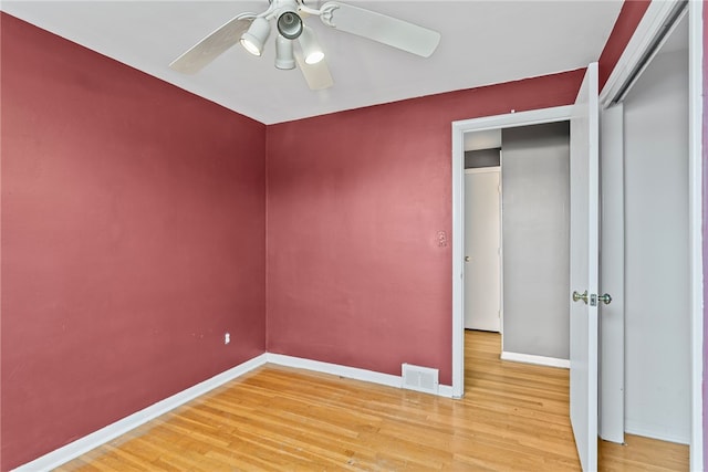 unfurnished bedroom featuring baseboards, visible vents, ceiling fan, and wood finished floors