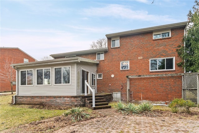 back of property featuring brick siding