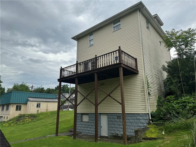 back of house featuring a lawn and a wooden deck