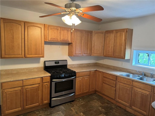 kitchen featuring brown cabinets, gas range, light countertops, and a sink