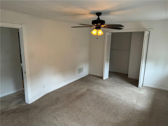 unfurnished bedroom featuring baseboards, visible vents, a ceiling fan, carpet floors, and a closet