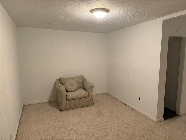 unfurnished room with carpet, baseboards, and a textured ceiling