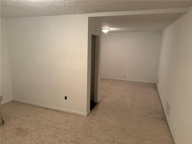 basement with carpet floors, a textured ceiling, and baseboards