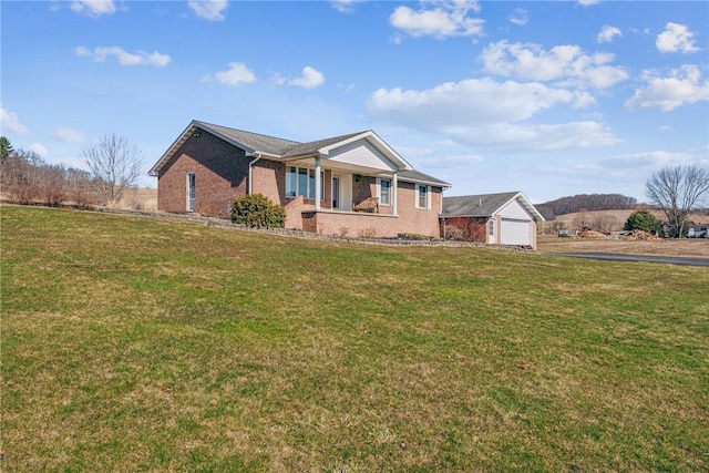 ranch-style house featuring a garage, brick siding, covered porch, and a front yard