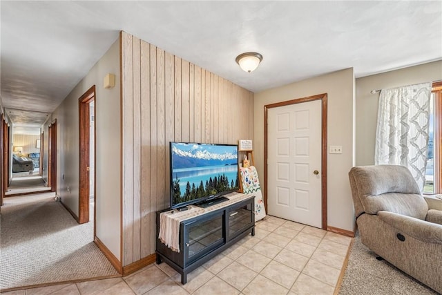 living area featuring light colored carpet, baseboards, and light tile patterned floors