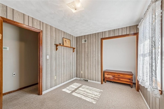 unfurnished room featuring carpet floors, baseboards, and visible vents