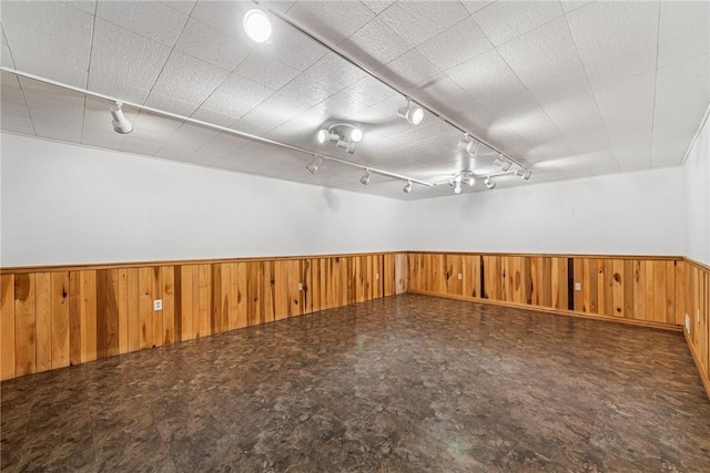 unfurnished room with a wainscoted wall and wooden walls