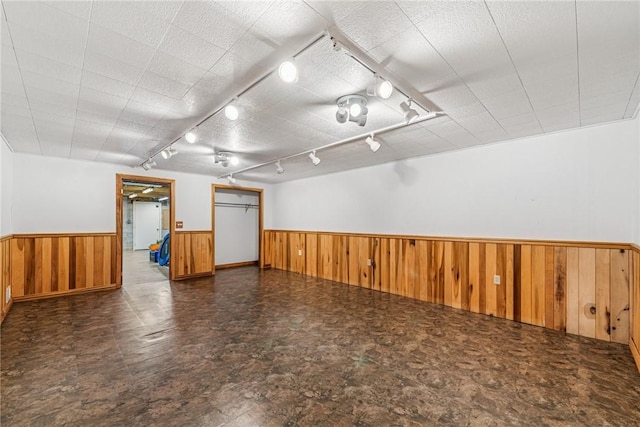 bonus room with wood walls and wainscoting