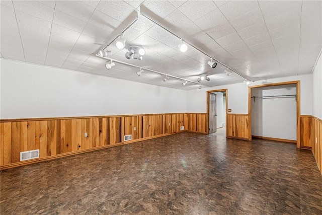 interior space with wainscoting, visible vents, and wooden walls