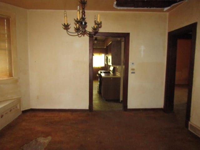 unfurnished dining area with a notable chandelier and baseboards