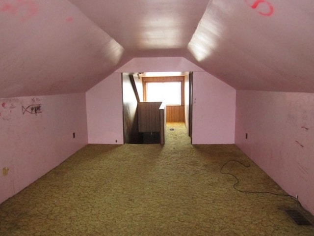 additional living space featuring lofted ceiling, visible vents, and carpet flooring