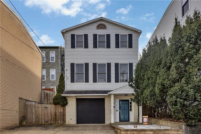 view of front of property featuring driveway, brick siding, an attached garage, and fence