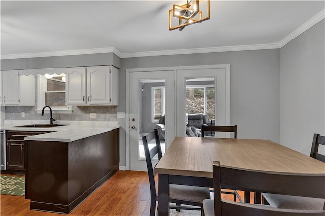 dining area featuring ornamental molding, light wood finished floors, and an inviting chandelier