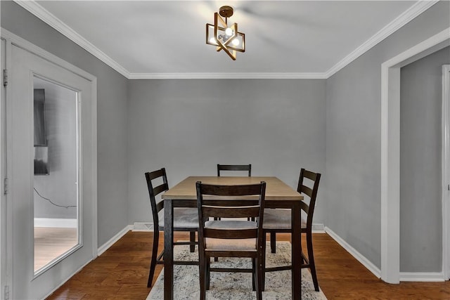 dining area featuring baseboards, dark wood-style flooring, and ornamental molding