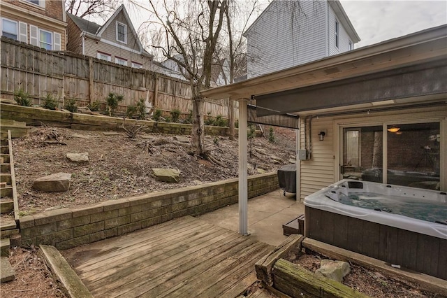 wooden terrace with a hot tub and fence