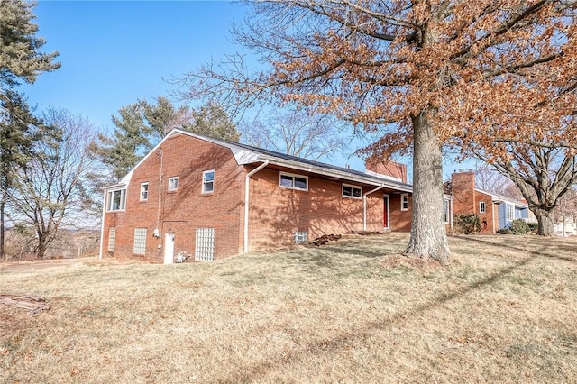 view of home's exterior with a yard and brick siding