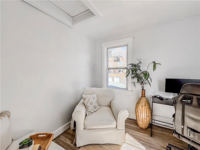 living area with baseboards and wood finished floors