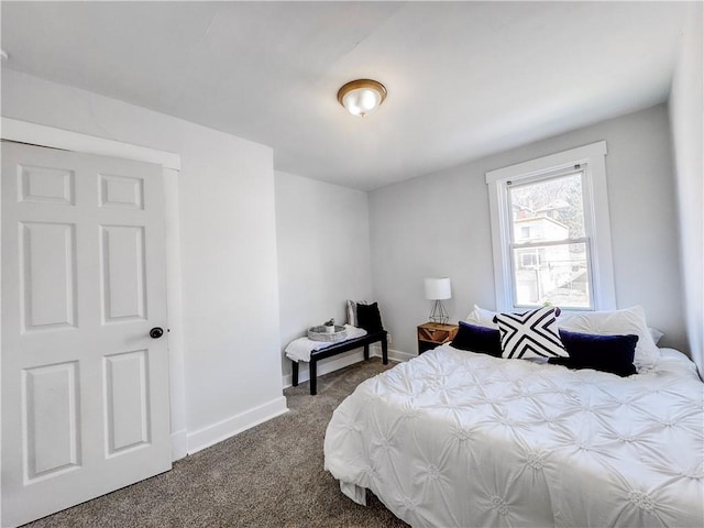 bedroom featuring dark colored carpet and baseboards