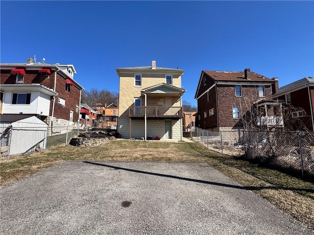 rear view of house with a residential view, fence, and brick siding