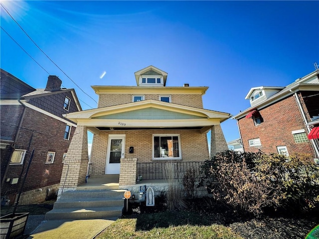 traditional style home featuring a porch and brick siding