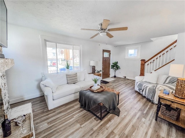 living room with light wood-style floors, stairway, and baseboards