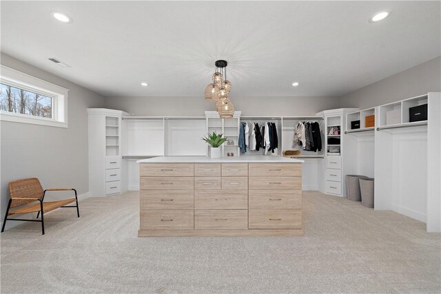 walk in closet with light carpet