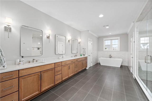 bathroom featuring a freestanding tub, a sink, tile patterned floors, double vanity, and a stall shower