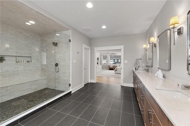 ensuite bathroom with a stall shower, baseboards, ensuite bath, and tile patterned floors