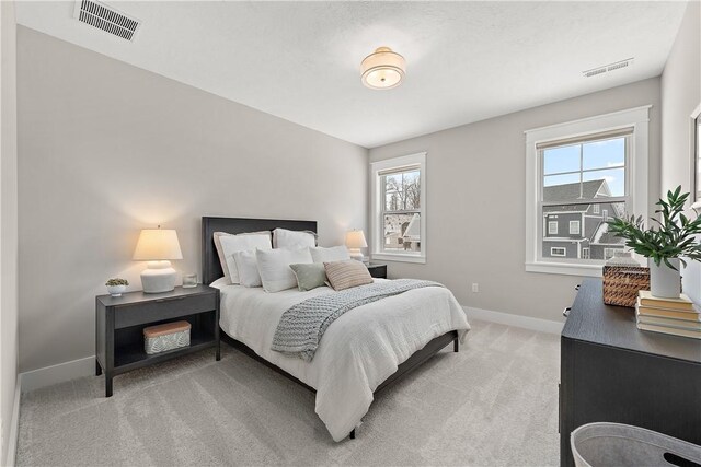 bedroom featuring light carpet, baseboards, and visible vents