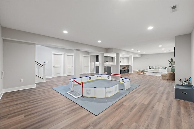 recreation room featuring baseboards, wood finished floors, visible vents, and recessed lighting