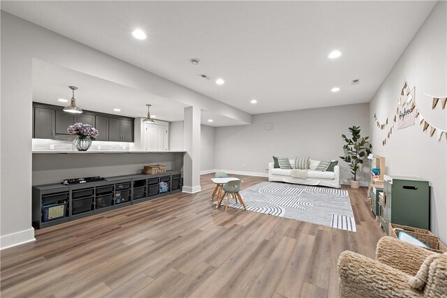 living area featuring baseboards, wood finished floors, visible vents, and recessed lighting