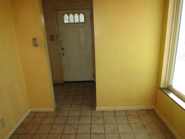 empty room featuring light tile patterned floors and baseboards