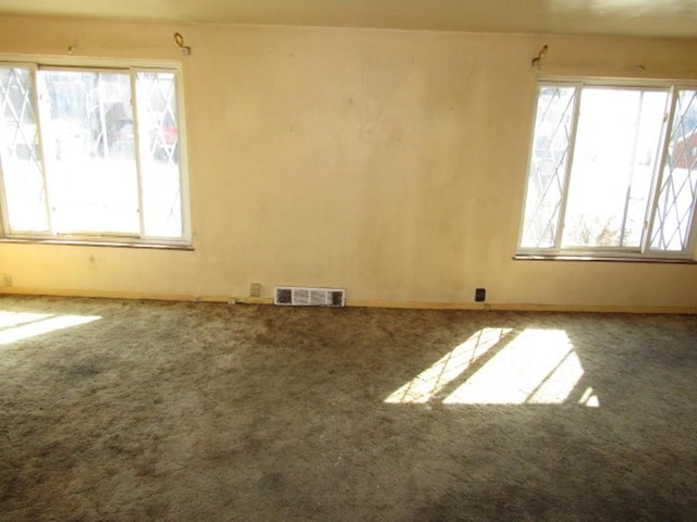 carpeted empty room with visible vents and baseboards