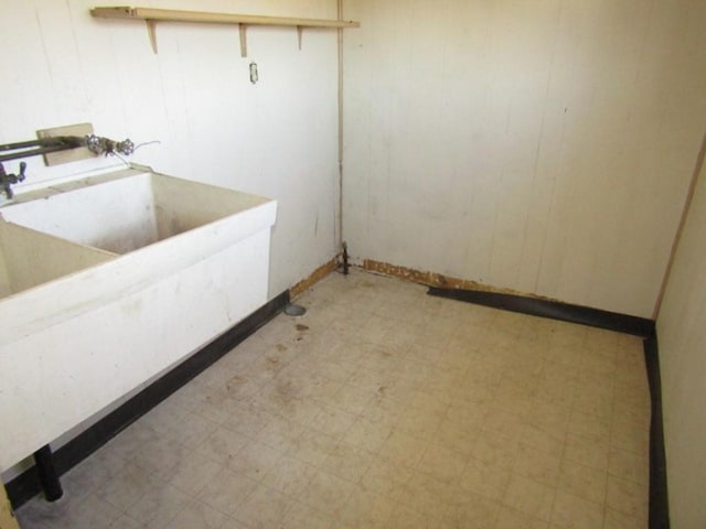 laundry room with light floors and wood walls