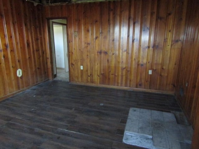 empty room with wood walls and wood finished floors