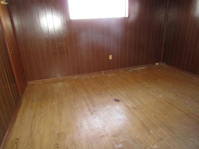 spare room featuring wooden walls and wood finished floors