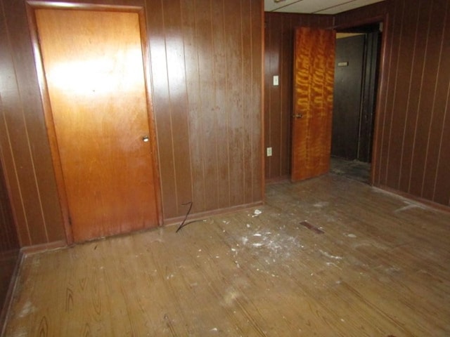 empty room with wood finished floors and wooden walls