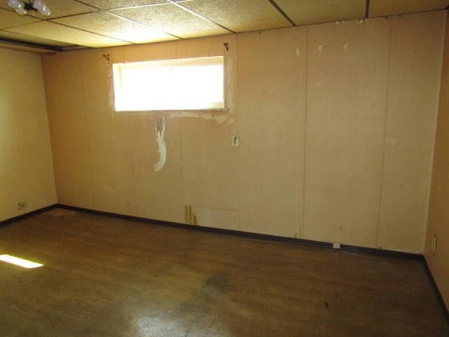 below grade area featuring wood finished floors and a paneled ceiling